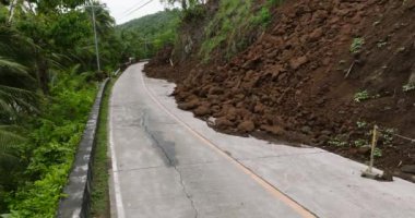 Dağ uçurumundan gelen toprak kaymaları dağ yolunu kapatıyor. Camiguin, Filipinler.