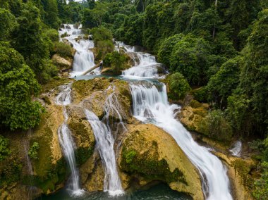 Kayaların üzerinden hızlı akan tropik şelaleler. Aliwagwag Şelalesi. Mindanao, Filipinler.