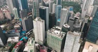 Makati şehrinin yüksek binaları ve binaları üzerinde uçuyor. Metro Manila, Filipinler. Şehir manzarası.