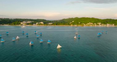 Günbatımlı tropik beyaz plaj. Otelleri ve tekneleri olan Boracay. Filipinler.