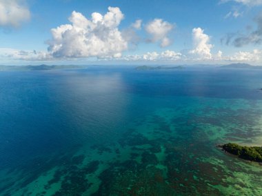 Mercan resifli turkuaz deniz suyu. Mavi gökyüzü ve bulutlar. El Nido, Filipinler.