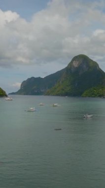 Tropikal Ada 'da denizde yüzen bir grup tekne. El Nido, Filipinler. Dikey görünüm.