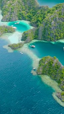 Koron, Palawan 'da mavi suyu olan turist tekneleri ve lagünlerin havadan görüntüsü. Filipinler. Dikey görünüm.