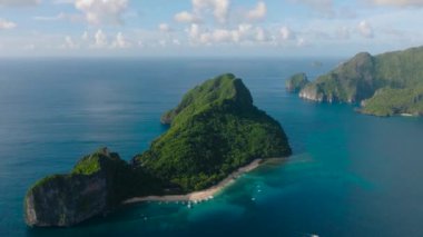 Yeşil dağı ve kumlu plajı olan helikopter adası. El Nido, Palawan. Filipinler.