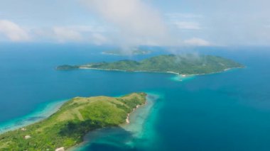 Plajları sislerle kaplı tropik ada manzarası. Mavi gökyüzü ve bulutlar. Romblon, Filipinler.
