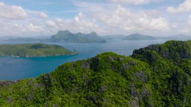 Matinloc Adası üzerinden Inambuyod Adası 'nın havadan görüntüsü. Mavi gökyüzü ve bulutlar. El Nido, Palawan. Filipinler.