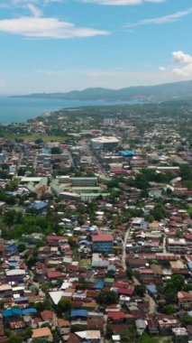 Iligan City 'deki yerleşim köyü. Mavi gökyüzü ve bulutlar. Kuzey Mindanao, Filipinler. Dikey video.