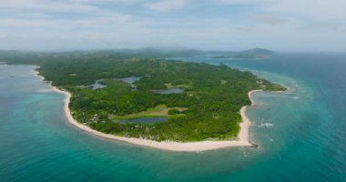 Okyanus dalgaları, turkuaz deniz suyu ve insansız hava aracı manzaralı beyaz kumlu sahil. Santa Fe, Tablas, Romblon. Filipinler.