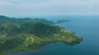 Tropikal Ada 'daki yeşil ormanlı dağın en üst manzarası. Mavi gökyüzü ve bulutlar. Mindanao, Filipinler.