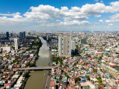 Şehir manzarası: Nehir kenarındaki modern binaların, otellerin ve evlerin insansız hava aracı görüntüsü. Manila, Filipinler.