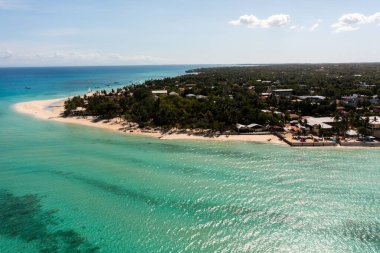 Turkuaz deniz sularının üzerinde güneş ışığı yansıması. Kota sahilindeki kumlara okyanus dalgaları çarpıyor. Bantayan Adası. Cebu, Filipinler.