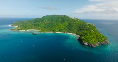 Mavi denizde tekneleri olan tropik bir ada. Romblon 'daki Cobrador Adası. Filipinler.