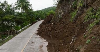 Otoyolun yarısında dağ toprağı çökmüş. Şiddetli yağış nedeniyle heyelan. Camiguin, Filipinler.