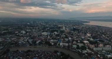Davao City: Alacakaranlıkta bir sahil şehri. Bulutlu gün batımı ve gökyüzü. Mindanao, Filipinler.