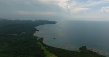 Tropikal adada yeşil orman, mavi deniz ve dalgalar. Mindanao, Filipinler.