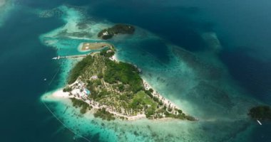 Gök mavisi su ve dalgalarla çevrili beyaz sahilde yapılan hava araştırması. Samal 'da Malpano Adaları. Davao, Filipinler.