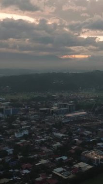 Şehir ve alacakaranlık bulutlu günbatımı. Davao Şehri. Mindanao, Filipinler. Dikey görünüm.