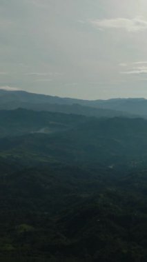Yoğun orman ve bulutlarla kaplı tropik dağ tepelerinin hava manzarası. Mindanao, Filipinler. Dikey görünüm.