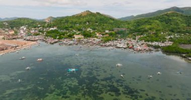 Coron 'daki Stilt evleri. Turkuaz deniz suyunun üzerinde yüzen tekneler. Palawan, Filipinler.