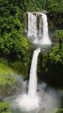 Limunsudan Şelalesi 'nde yemyeşil bir bitki örtüsü, Filipinler' de iki katmanlı su damlası. Mindanao. Dikey görünüm.