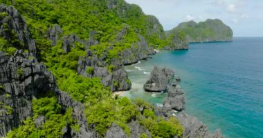 Okyanus dalgalarının Matinloc Adası 'ndaki kumsallara ve kayalara çarptığı hava manzarası. El Nido, Palawan. Filipinler.