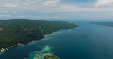 Yeşil dağ, mavi deniz, gökyüzü ve bulutları olan tropikal adanın en üst manzarası. Samal Adası. Davao, Filipinler.