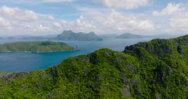 Matinloc Adası üzerinden Inambuyod Adası 'nın havadan görüntüsü. Mavi gökyüzü ve bulutlar. El Nido, Palawan. Filipinler.