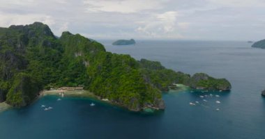 Miniloc Adası 'ndaki sahil tatil köyleri ve botlar. El Nido, Palawan. Filipinler.