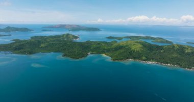 Yağmur ormanları olan tropikal adaların manzarası. Mavi deniz yüzeyi, mavi gökyüzü ve bulutlar. Deniz Burnu. Mindanao, Filipinler.