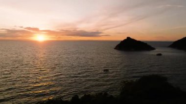 Gün batımında sakin bir okyanus manzarası siluetli adalar ve yumuşak akşam ışığı altında tekneler. Koh Tao, Tayland.