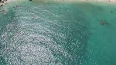 Turkuaz sular, içi palmiye ağaçları ve canlı şemsiyelerle dolu kumlu bir plajla karşılaşıyor. Crystal Bay Sahili. Ko Samui, Tayland.