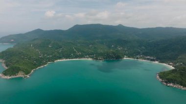 Bereketli yeşil tepeler ve durgun turkuaz denizle çevrili beyaz kumlu plajları olan körfez. Tanga Nai Pan Yai Sahili. Ko Pha Ngan, Tayland.