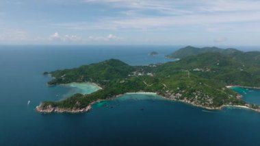 Issız kayalık çıkıntıları, yemyeşil yemyeşil suları ve berrak turkuaz suları olan bir sahil şeridi. Koh Tao, Tayland.