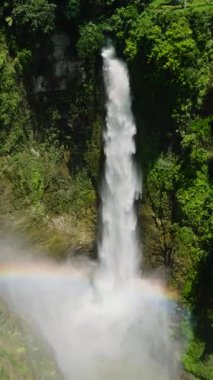 Hikong Bente Şelalesi 'nin tepesindeki gökkuşağı dağ ormanları, yağmur ormanları ve yeşil ağaçlarla çevrilidir. Sebu Gölü. Mindanao, Filipinler. Dikey görünüm.