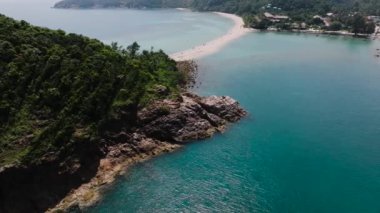 Bereketli yeşillik ve turkuaz suyla çevrili kayalık kıyı şeridini birbirine bağlayan kumlu bir yol. Ko Ma Sahili. Ko Pha Ngan, Tayland.