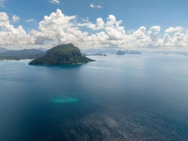 Mavi gökyüzü ve bulutların altında mavi denizi olan adalar. El Nido, Palawan. Filipinler.