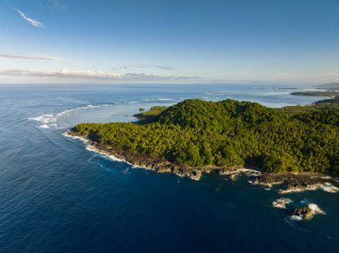 Tropik adaya dokunan güzel okyanus dalgaları. Mavi gökyüzü ve bulutlar. Seyahat konsepti. Surigao del Sur. Mindanao, Filipinler.