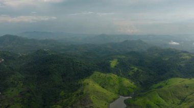 Yağmur ormanları ve tarım arazileri olan bir dağ vadisi olan dağ yamaçlarının insansız hava aracı. Mindanao, Filipinler.