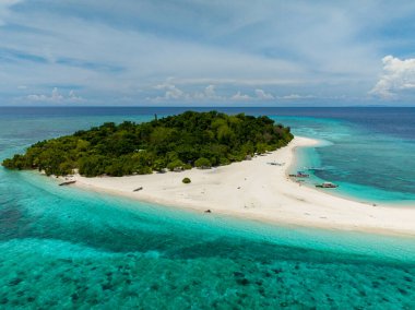 Flying over the white beach with turquoise water in Mantigue Island. Blue sky and clouds. Camiguin, Philippines. clipart