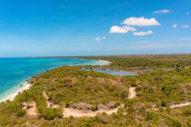 Mercan resifli turkuaz deniz yüzeyli tropik bir manzara. Açık mavi gökyüzü ve bulutların altındaki Bantayan Adası. Cebu, Filipinler.