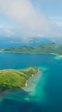 Plajları sislerle kaplı tropik ada manzarası. Mavi gökyüzü ve bulutlar. Romblon, Filipinler. Dikey görünüm.