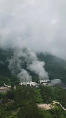 Buhar ve borularla Jeotermal Üretim Alanının drone görüntüsü. Bir enerji santralinde yenilenebilir enerji üretimi. Mindanao, Filipinler. Dikey görünüm.