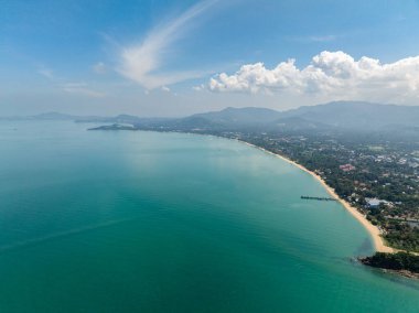Turkuaz suları ve berrak bir gökyüzünün altında uzanan kumlu plajları olan el değmemiş bir sahil şeridi. Koh Samui, Tayland.