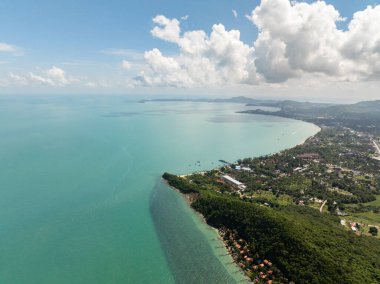 Güneşli mavi gökyüzünün altında palmiye ağaçları ve turkuaz sularla kaplı tropik bir sahil. Koh Samui, Tayland.