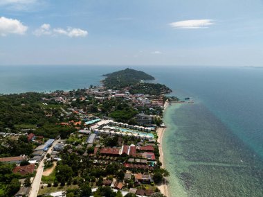 Sahil köyü, arka planda tepeler ve kıyı şeridi boyunca turkuaz deniz olan yeşilliklerle çevrili. Ko Pha Ngan, Tayland.