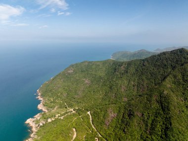 Bereketli yeşil tepelerin sakin mavi okyanusla buluşması, sakin ve geniş doğal bir manzara. Ko Pha Ngan, Tayland.