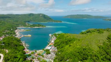 Berrak mavi sular ve manzaralı yeşil tepelerle çevrili canlı bir sahil kasabası. Romblon, Filipinler.