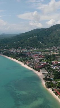 Kıyı şeridi boyunca uzanan plajlar ve arka planda yükselen orman dağları. Ko Samui, Tayland.