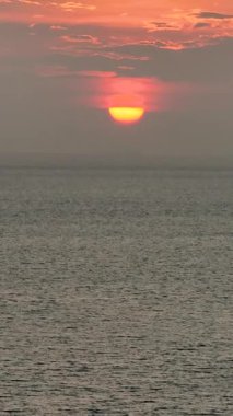 Sakin bir okyanusun üzerinde yansıyan altın gün batımının havadan görünüşü. Ko Pha Ngan, Tayland.