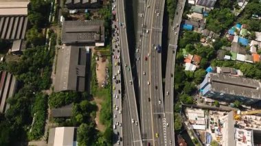 Endüstriyel binalar ve yeşil alanlarla çevrili birçok şeritli şehir otoyolu. Bangkok, Tayland.